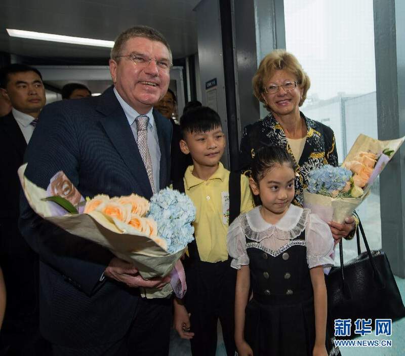 南京禄口机场，两名南京小朋友向巴赫夫妇献花并合影留念。