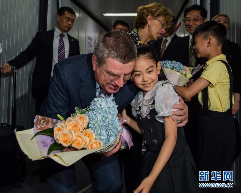 南京禄口机场，两名南京小朋友向巴赫夫妇献花。