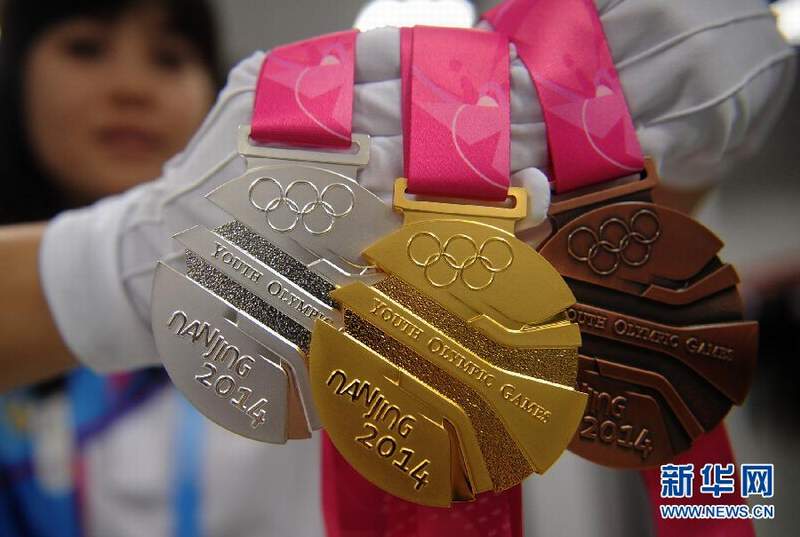 青奥组委会工作人员展示青奥会奖牌
