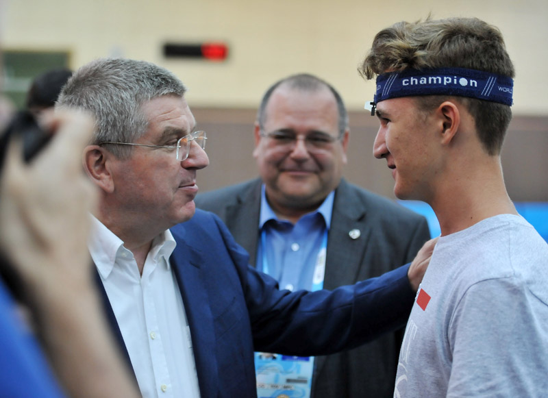 国际奥委会主席巴赫（左）与获得男子10米气手枪季军的法国选手爱德华・多尔通交谈
