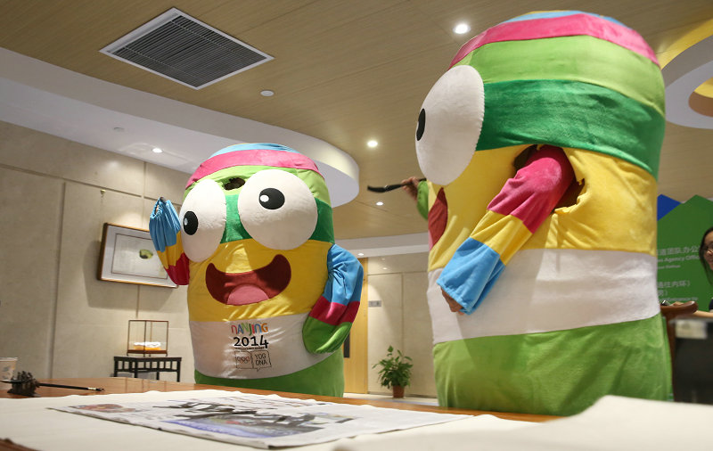 8月19日，南京青奥会吉祥物“�i�i”来到主新闻中心，在这里一展书法技艺。