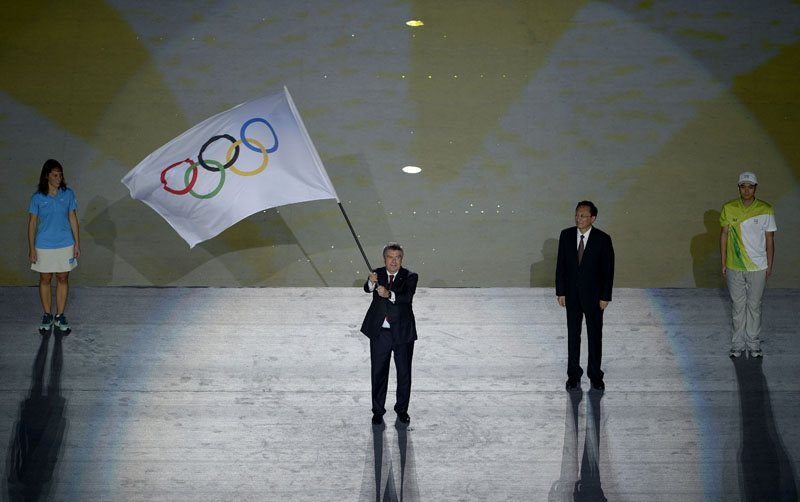 国际奥委会主席托马斯・巴赫（左二）在闭幕式上挥舞奥林匹克会旗 新华社记者张宏祥摄