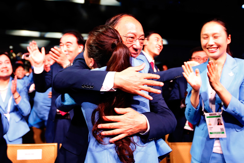 中國奧委會主席、國家體育總局局長劉鵬（中）與李妮娜擁抱慶祝
