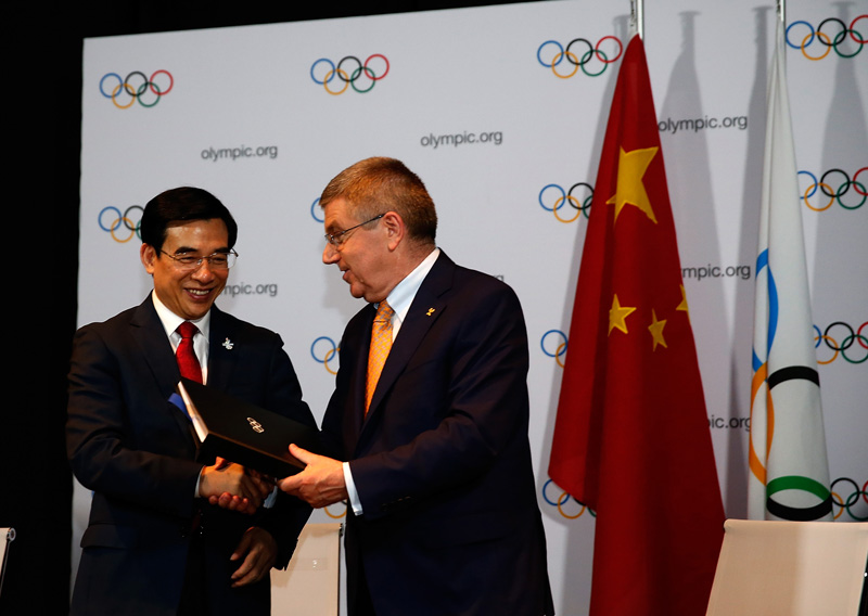 國際奧委會主席巴赫（右）與北京市市長王安順在簽約儀式上握手致意