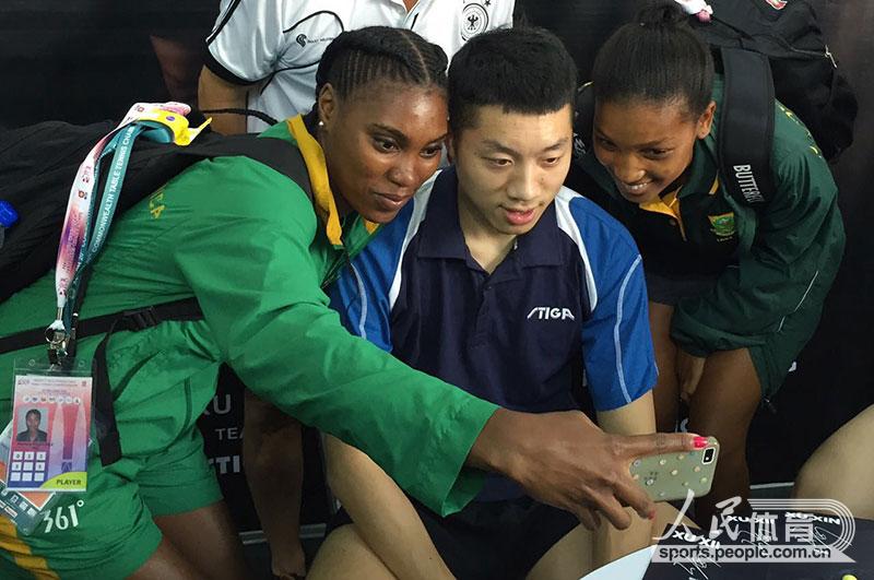 南非女球員意外擠到瑞典斯帝卡器材展廳，與中國世界冠軍球員許昕玩起了自拍。