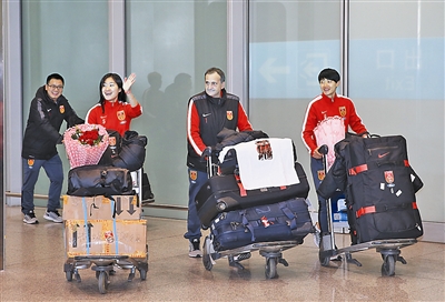 中国女足球员吴海燕（左二）与主教练布鲁诺（右二）等走出机场。 新华社照片