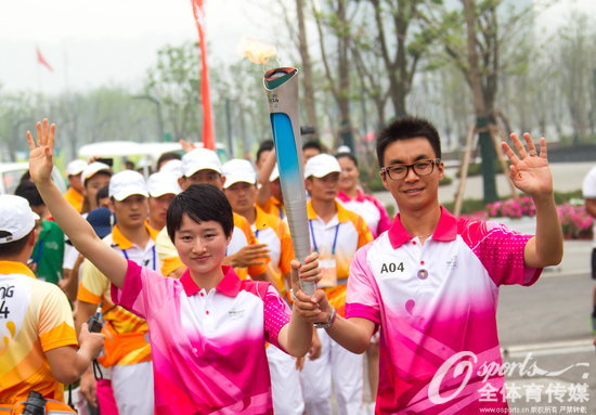 跆拳道奧運會冠軍吳靜鈺（左）與丈夫侯琨在進行2014年南京青奧會火炬傳遞。（資料圖）