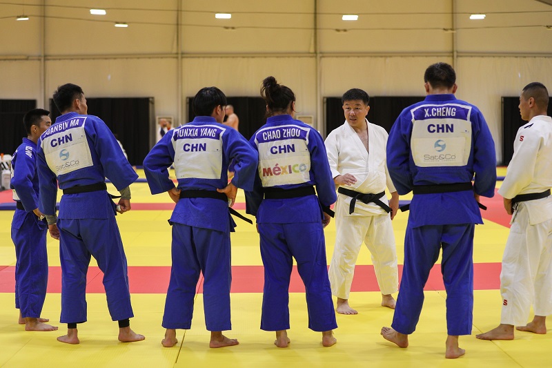 中國柔道隊教練鄭勛在賽前訓練中與隊員交流。