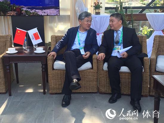 人民日報副總編輯謝國明（左）與人民日報體育部主任李中文親切交談。人民網記者 史家民攝