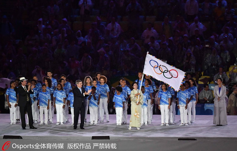 东京市新任市长小池百合子从国际奥委会主席巴赫手中接过奥林匹克会旗