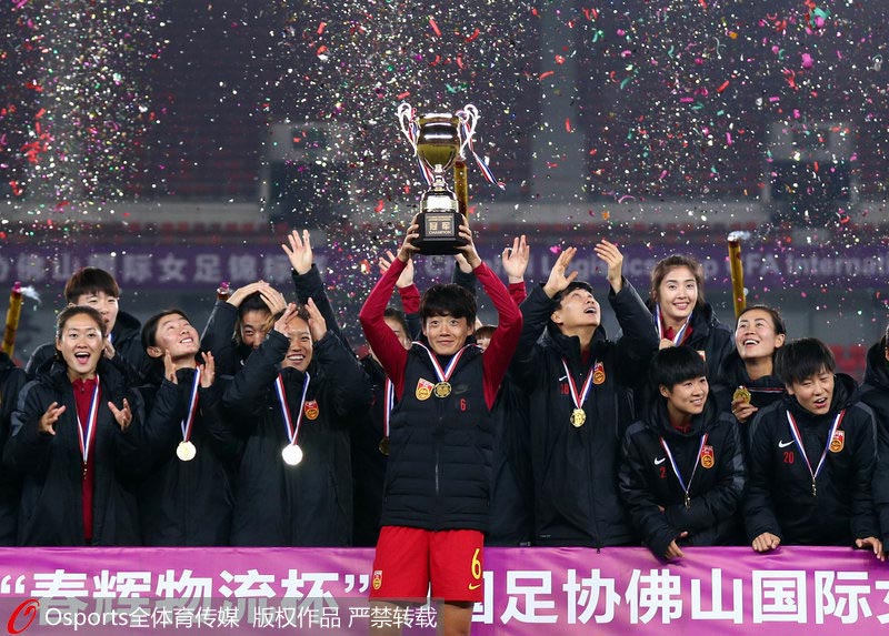女足姑娘捧起冠軍獎杯。