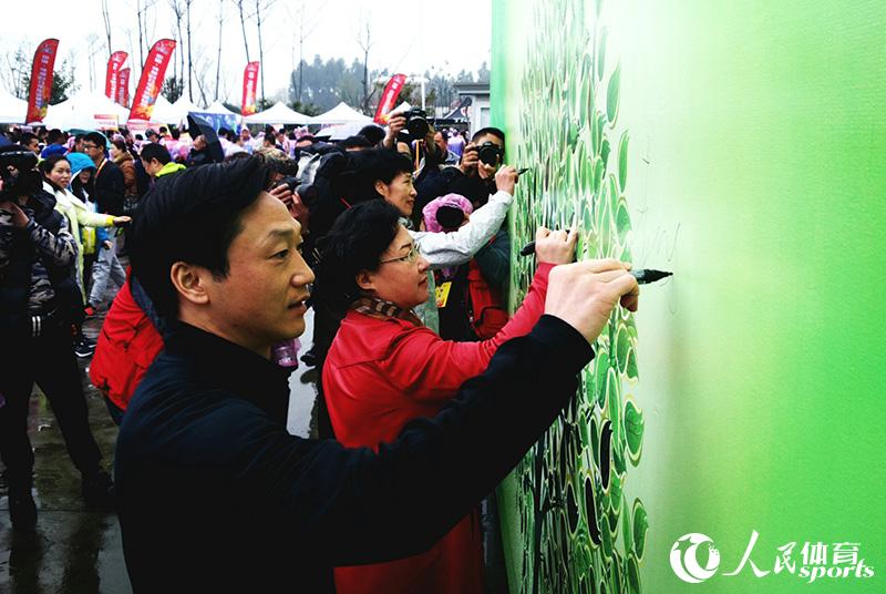 有關領導和嘉賓在“我愛成都 健康成都 低碳環保 綠色出行”簽名樹上簽名。