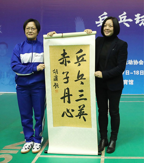 国家体育总局乒羽中心副主任柳屹向姜永宁的女儿姜小英赠送书法纪念品
