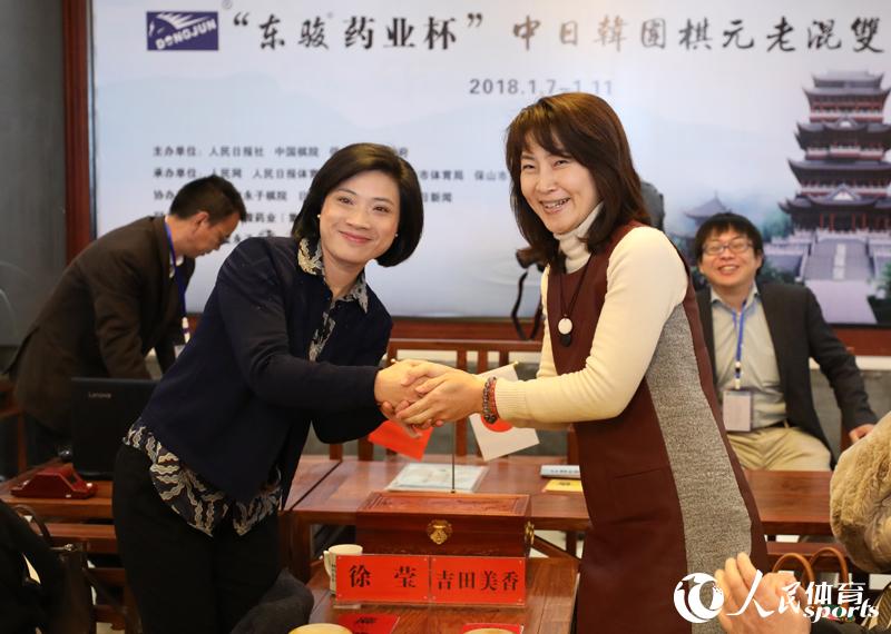 中日女選手徐瑩（左）與吉田美香賽前熱情握手。人民網 趙欣悅攝