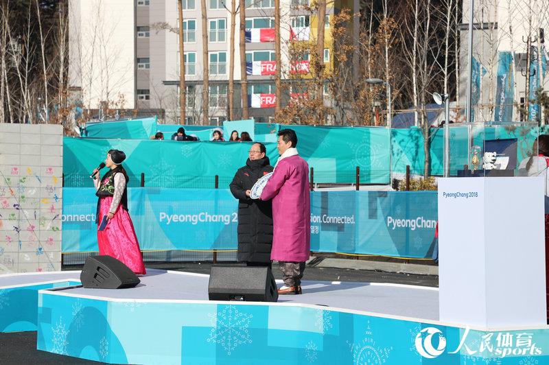 中國冬奧代表團團長苟仲文向奧運村村長金基勛互換禮物