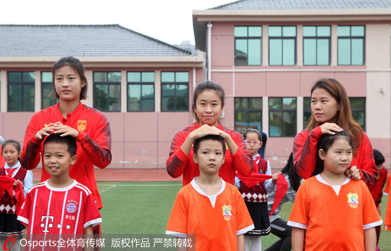 中國女足姑娘用雙手為小學生遮雨感動眾人。