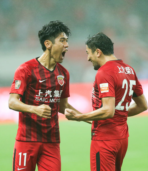11月7日，上海上港隊球員艾哈邁多夫（右）與隊友呂文君在比賽中慶祝進球。 新華社記者丁汀攝