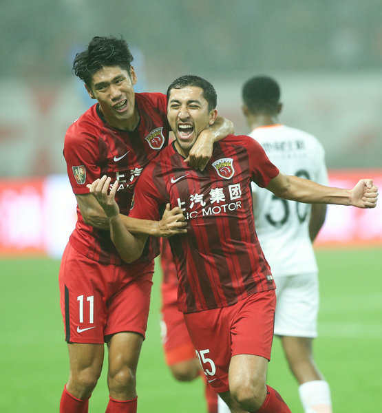 11月7日，上海上港隊球員艾哈邁多夫（前右）與隊友呂文君在比賽中慶祝進球。新華社記者丁汀攝