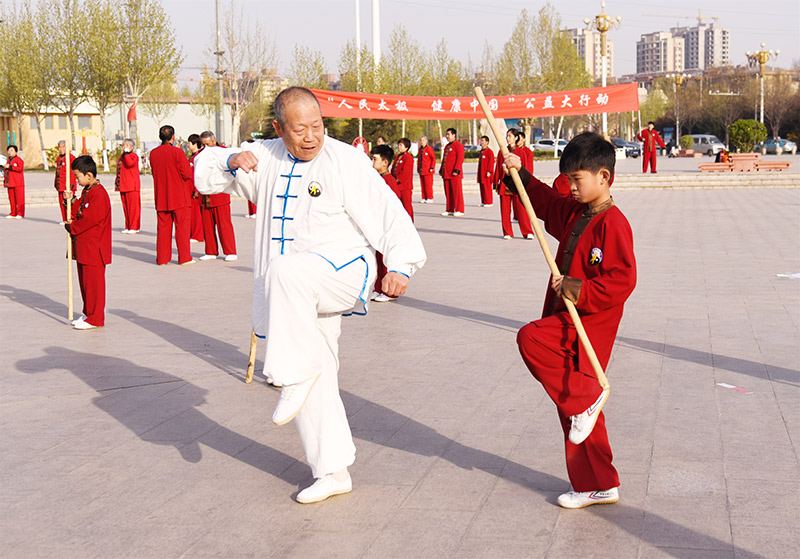 4月7日，河北省王其和太極拳協會會員在任縣人民廣場集體習練王其和太極拳，圖為一位老者指導晚輩學習。