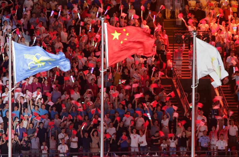 中華人民共和國國旗、中華人民共和國少數民族傳統體育運動會會旗和第十一屆全國少數民族傳統體育運動會會旗在鄭州奧林匹克體育中心迎風飄揚。麻翛然攝