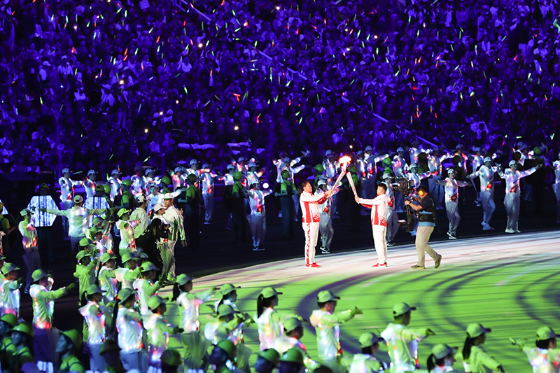 中國運動員張文秀（左）為第一棒火炬手王皓點燃火炬