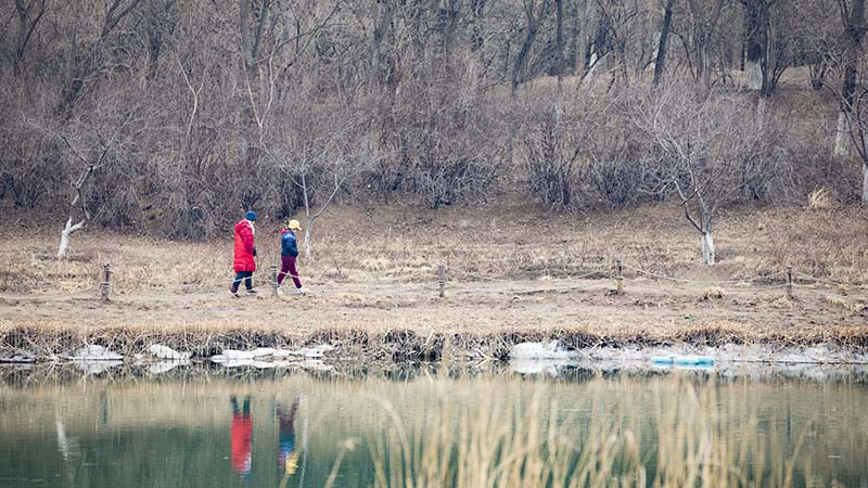 游客在空曠的湖邊散步