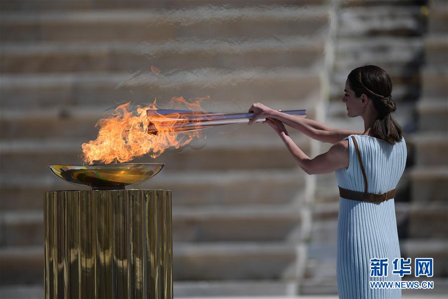 扮演最高女祭司的希臘女演員桑西·喬治烏從聖火盆中點燃火炬。新華社發（阿裡斯·麥西尼攝）