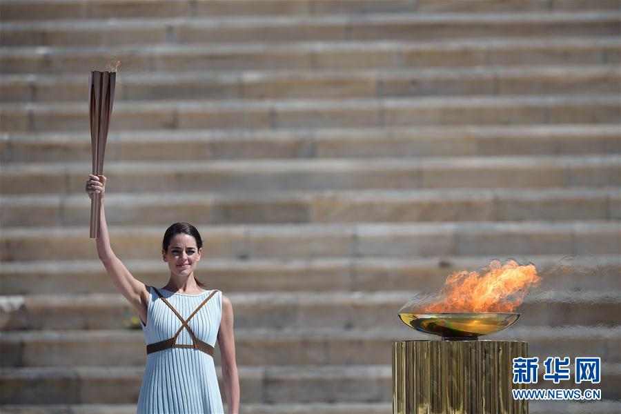 扮演最高女祭司的希臘女演員桑西·喬治烏手舉聖火火炬。新華社發（阿裡斯·麥西尼攝）